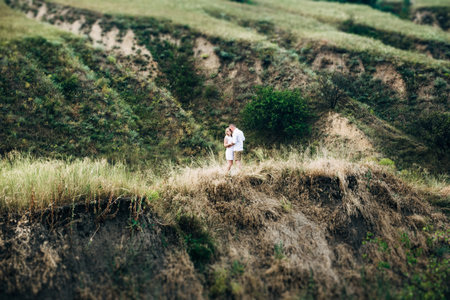 a guy with a girl in light clothes on the background of a green canyon of erosion of the earthの写真素材