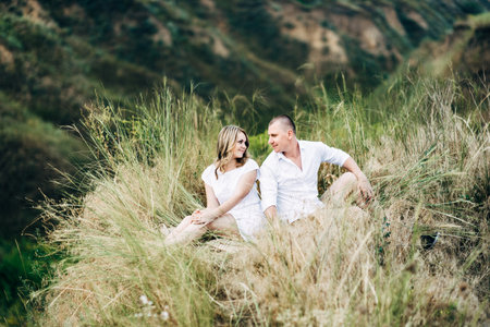 a guy with a girl in light clothes on the background of a green canyon of erosion of the earthの写真素材