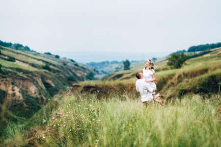 a guy with a girl in light clothes on the background of a green canyon of erosion of the earthの写真素材