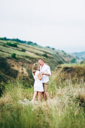 a guy with a girl in light clothes on the background of a green canyon of erosion of the earthの写真素材