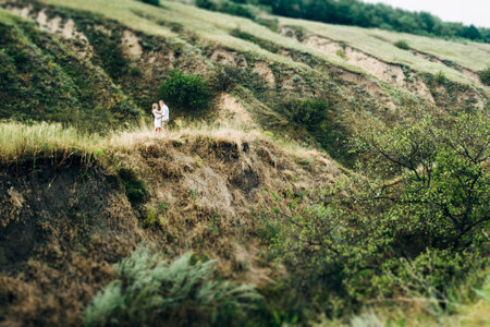 a guy with a girl in light clothes on the background of a green canyon of erosion of the earthの写真素材