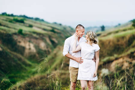 a guy with a girl in light clothes on the background of a green canyon of erosion of the earthの写真素材