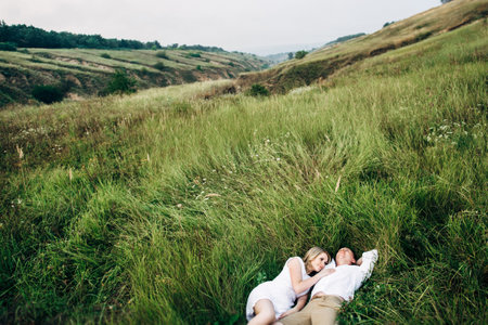 a guy with a girl in light clothes on the background of a green canyon of erosion of the earthの写真素材