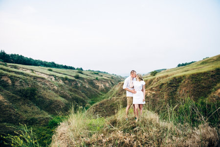 a guy with a girl in light clothes on the background of a green canyon of erosion of the earthの写真素材