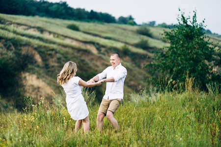 a guy with a girl in light clothes on the background of a green canyon of erosion of the earthの写真素材