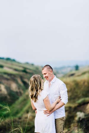 a guy with a girl in light clothes on the background of a green canyon of erosion of the earthの写真素材