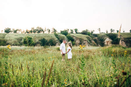 a guy with a girl in light clothes on the background of a green canyon of erosion of the earthの写真素材