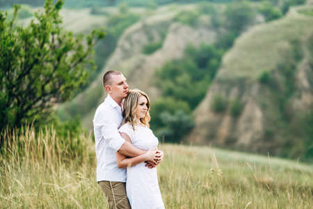 a guy with a girl in light clothes on the background of a green canyon of erosion of the earthの写真素材