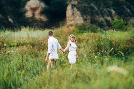 a guy with a girl in light clothes on the background of a green canyon of erosion of the earthの写真素材