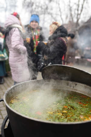 meat soup with herbs and spices boils over the fire in a large saucepanの写真素材