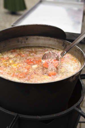 meat soup with herbs and spices boils over the fire in a large saucepanの写真素材