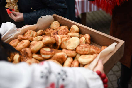 woman holding fried cakes on a large wooden trayの写真素材