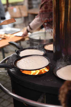 street cooking of pancakes on a large circular grillの写真素材