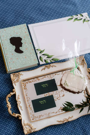 there is a book on the bed, a tray and a cakeの写真素材