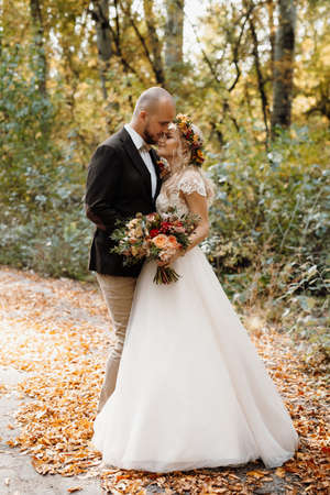 walk of the bride and groom through the autumn forest in Octoberの写真素材