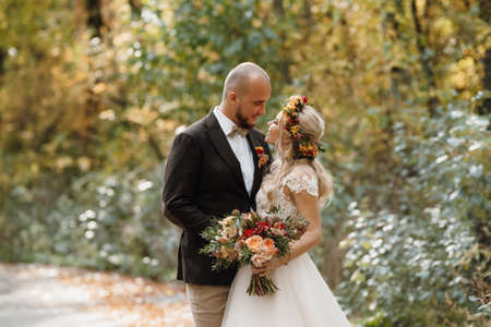 walk of the bride and groom through the autumn forest in Octoberの写真素材