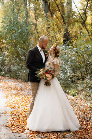 walk of the bride and groom through the autumn forest in Octoberの写真素材