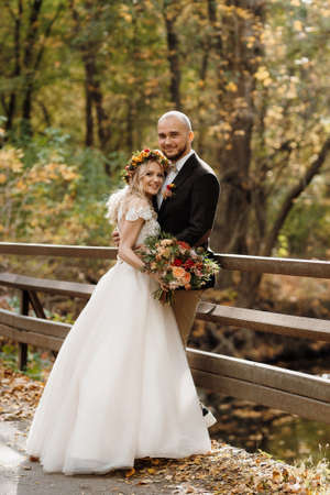 walk of the bride and groom through the autumn forest in Octoberの写真素材