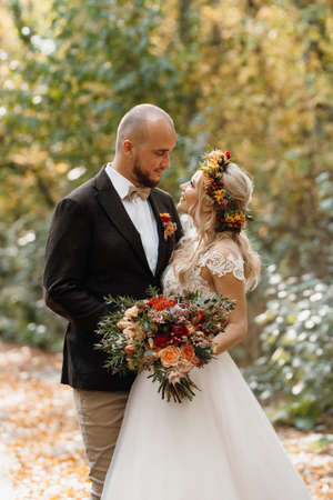 walk of the bride and groom through the autumn forest in Octoberの写真素材