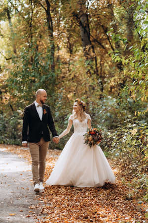 walk of the bride and groom through the autumn forest in Octoberの写真素材