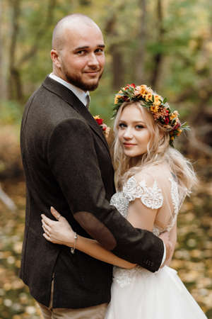 walk of the bride and groom through the autumn forest in Octoberの写真素材
