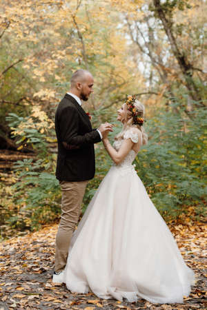 walk of the bride and groom through the autumn forest in Octoberの写真素材