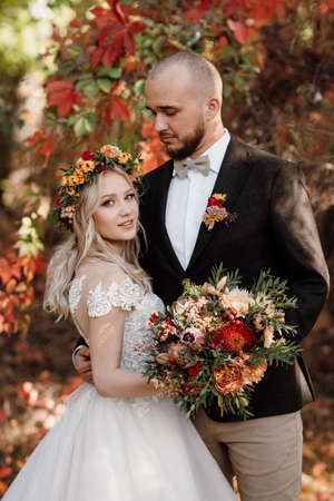 walk of the bride and groom through the autumn forest in Octoberの写真素材
