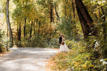 walk of the bride and groom through the autumn forest in Octoberの写真素材