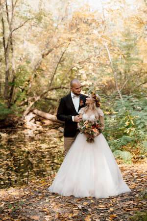 walk of the bride and groom through the autumn forest in Octoberの写真素材
