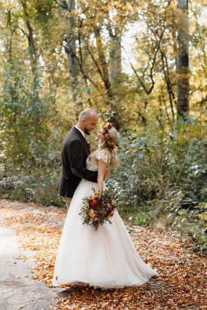 walk of the bride and groom through the autumn forest in Octoberの写真素材