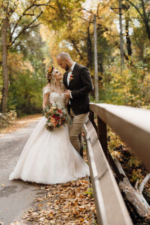 walk of the bride and groom through the autumn forest in Octoberの写真素材