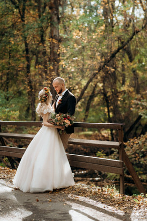 walk of the bride and groom through the autumn forest in Octoberの写真素材
