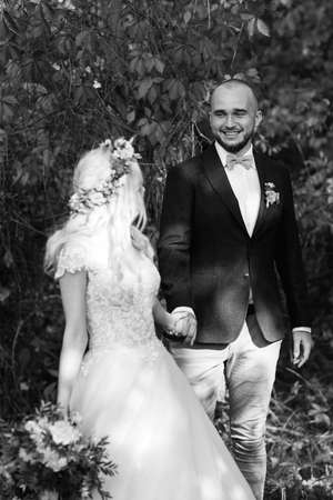 walk of the bride and groom through the autumn forest in Octoberの写真素材