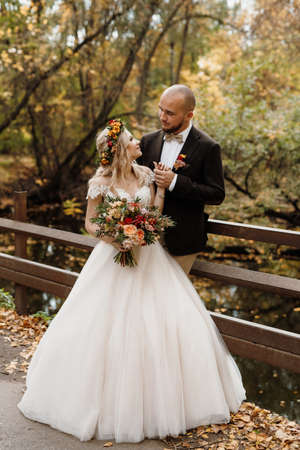 walk of the bride and groom through the autumn forest in Octoberの写真素材