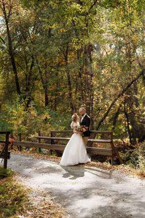 walk of the bride and groom through the autumn forest in Octoberの写真素材