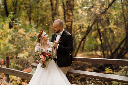 walk of the bride and groom through the autumn forest in Octoberの写真素材