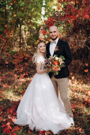 walk of the bride and groom through the autumn forest in Octoberの写真素材