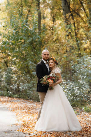 walk of the bride and groom through the autumn forest in Octoberの写真素材