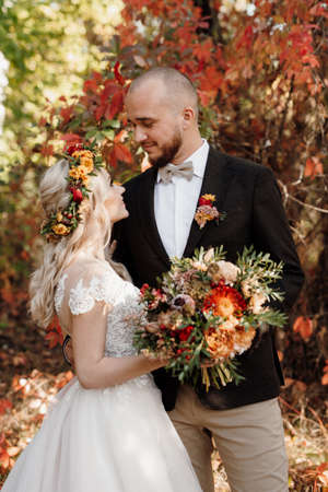 walk of the bride and groom through the autumn forest in Octoberの写真素材