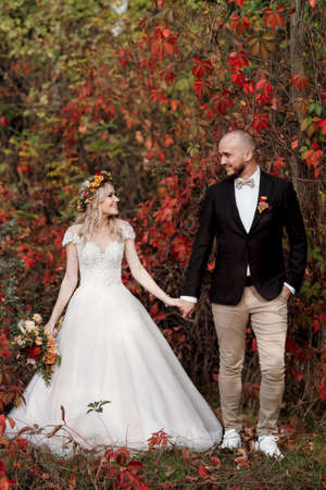 walk of the bride and groom through the autumn forest in Octoberの写真素材