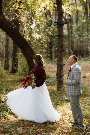 walk of the bride and groom through the autumn forest in Octoberの写真素材