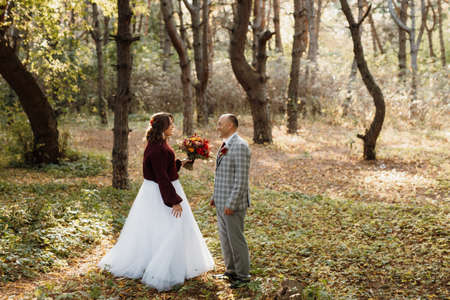 walk of the bride and groom through the autumn forest in Octoberの写真素材
