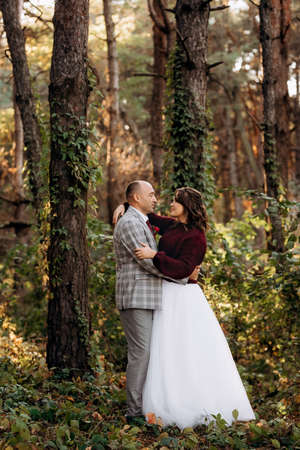 walk of the bride and groom through the autumn forest in Octoberの写真素材
