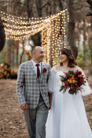 walk of the bride and groom through the autumn forest in Octoberの写真素材
