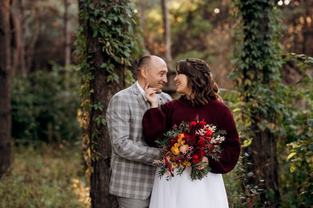 walk of the bride and groom through the autumn forest in Octoberの写真素材