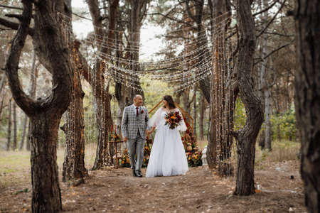 walk of the bride and groom through the autumn forest in Octoberの写真素材
