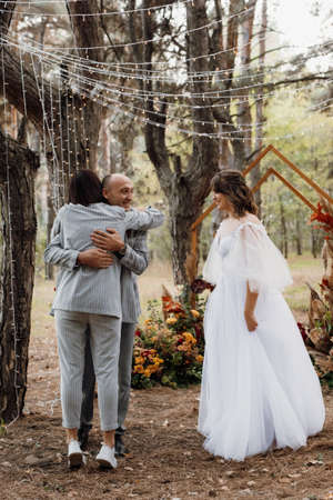 man and woman got engaged in autumn forest at wedding decorated ceremonyの写真素材