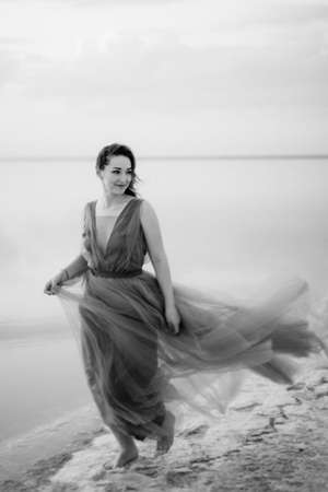 girl on the shore of a pink salt lake at sunsetの写真素材