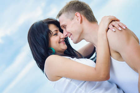 guy and a girl in jeans and white t-shirts on the seashore