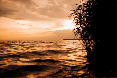 orange sunset over the sea with clouds in the skyの写真素材